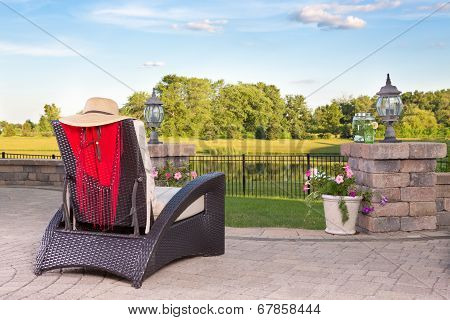 Vacant Wicker Armchair Overlooking A Tranquil Pond