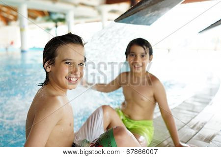 Happy little boys enjoying relaxing and splashing in water