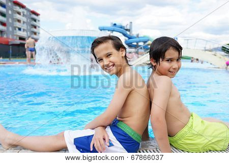 Happy little boys enjoying relaxing and splashing in water