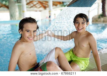 Happy little boys enjoying relaxing and splashing in water