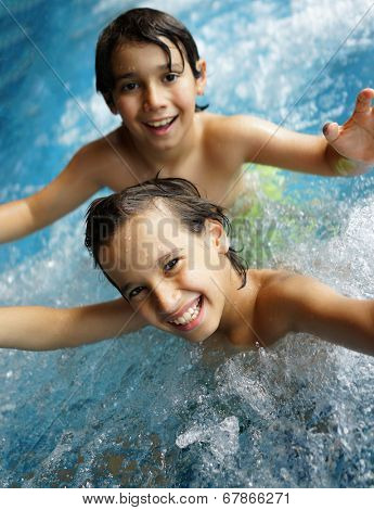 Happy little boys enjoying relaxing and splashing in water