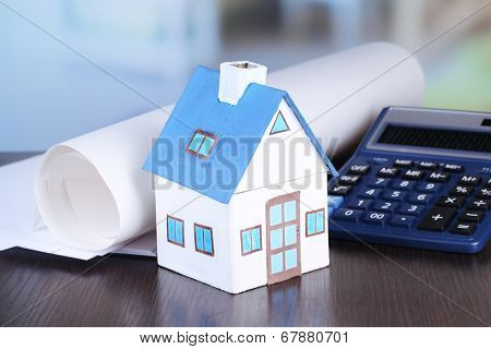 Toy house and calculator on table close-up