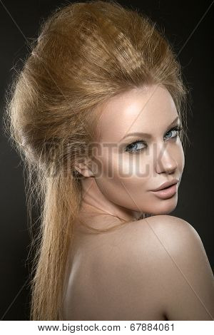 Beautiful red-haired girl with perfect skin and an unusual hairstyle.