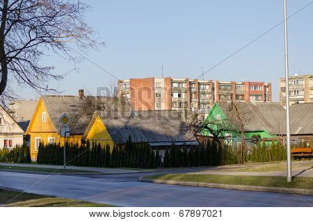 Rural Wooden House And Multistorey Red Brick House
