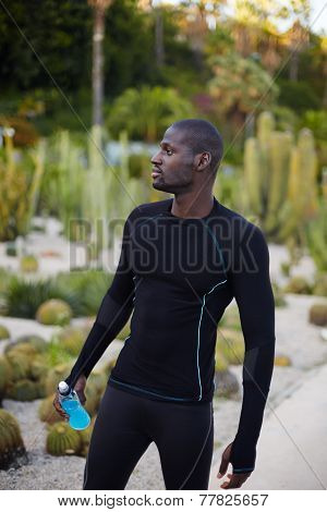 Attractive male runner taking break after workout outdoors