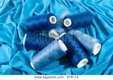 Blu bobine di fili su panno blu