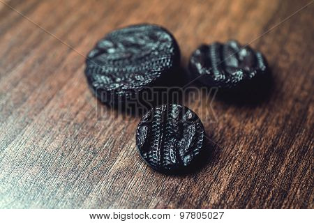 black buttons on wooden background