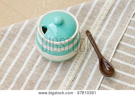 Green pastel porcelain jar and brown spoon with cute fabric.