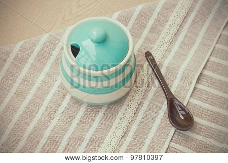 Green pastel porcelain jar and brown spoon in vintage style.