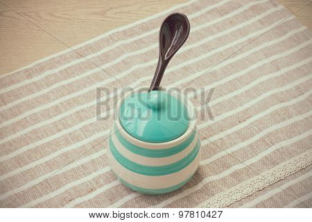 Green pastel porcelain jar and brown spoon in vintage style.