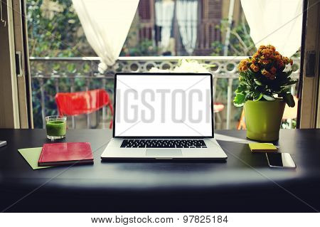 Workplace with open laptop computer with empty screen for your content or text message