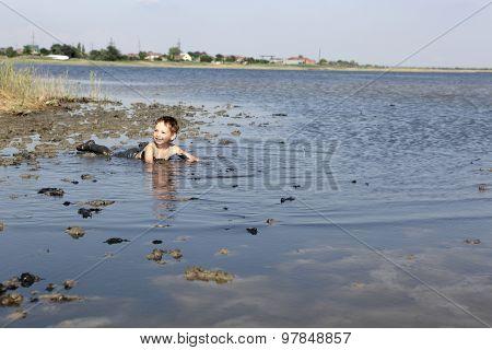 Child Lying In The Healthy Mud