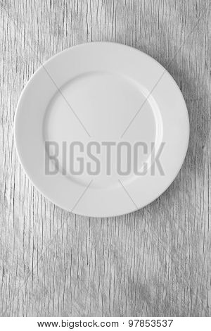 Empty white plate on wooden table