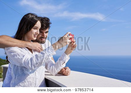 happy young couple taking selfie with cell phone