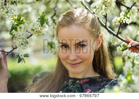 Beautiful girl standing in blossom garden