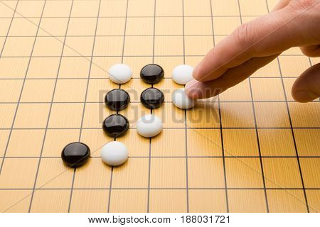 hand putting down piece of GO on board