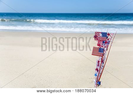 Patriotic USA background with flags and decorations on the sandy beach