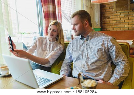 Business meeting in a cafe. Man and woman Looking at tablet pc.