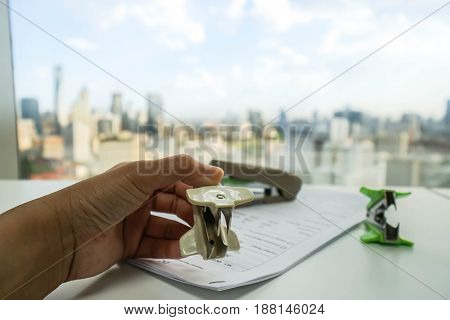 business women hold white staple remover on office documents