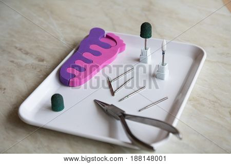Podology Instrument. Medical Burs, Red And Green Caps, Nippers On The White Medical Tray, Milling Cu