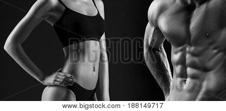 The colorless image of torso of attractive male and female bodys on black studio background.