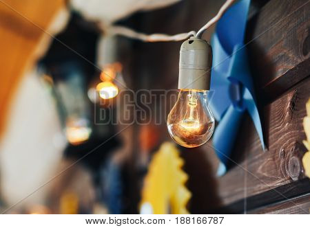 Incandescent lamps on a wooden wall decoration of the room