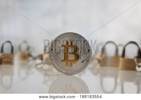 Silver Bitcoin Coin Near Gold Padlocks