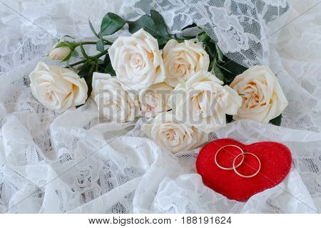 bouquet of white roses and lace with rings