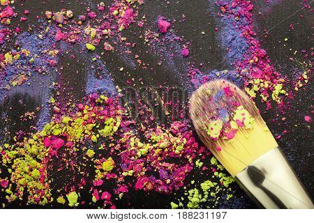Top view of makeup brush on colorful background with makeup powder