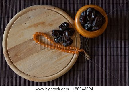 Date fruits or datulas with muslim beads for holy month of ramadan to break fasting from sunrise to sundown.