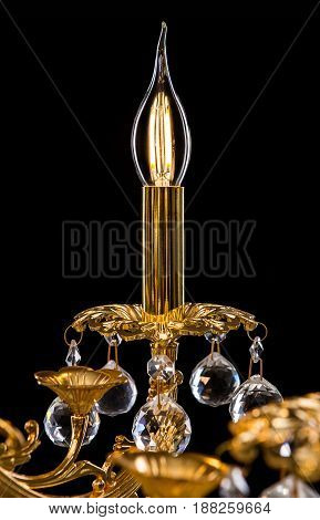 Classic Chandelier for interior decoration of the living room. Large chandelier close-up details decorated with crystals isolated on black background. Gold modern a piece of interior for designers.