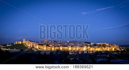Panoramic view of the historic city of Avila, at the blue hour, in Spain. the old city of Avila and its extramural churches were declared a World Heritage site by UNESCO