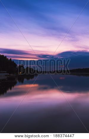 Scenery after sunset at the river in dusk colorful dramatic evening sky reflected in the water Khmelnytskyi Ukraine.