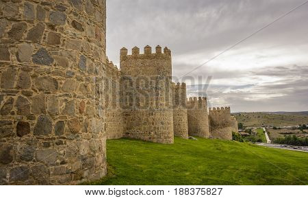 Walls of the historic city of Avila, at the blue hour, in Spain. the old city of Avila and its extramural churches were declared a World Heritage site by UNESCO