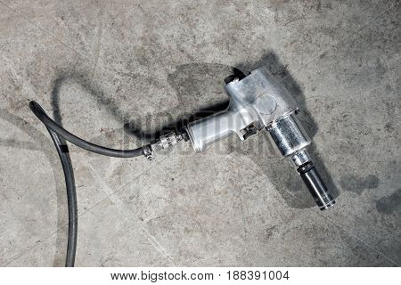 air gun to tighten a tire bolts on a suspended car at an auto shop.
