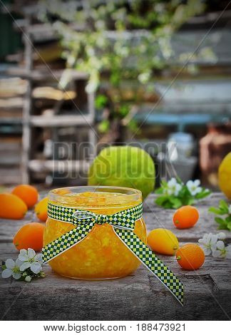 Orange marmalade on wooden table with fresh fruit and fresh flowers