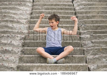 A Teenager In A T-shirt Sits On Concrete Steps
