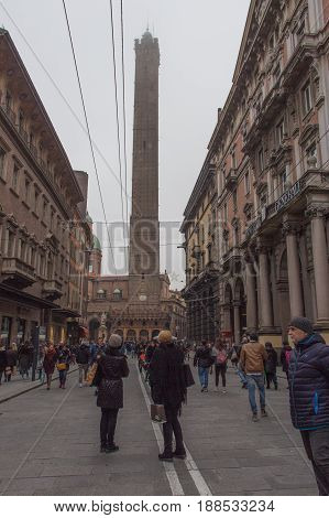 Italy Bologna - November 19 2016: the view the people on the street and Asinelli tower 97 m in the fog on November 19 2016 in Bologna Emilia Romagna Italy.