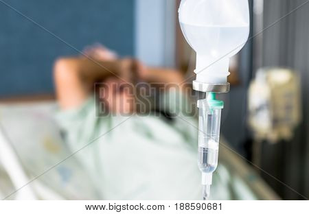 Close up saline IV drip over patient and Infusion pump in hospital