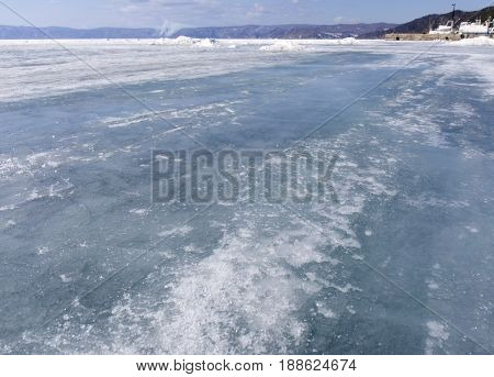 Baikal lake spring landscape view. Snow-covered surface of the ice lake. Winter