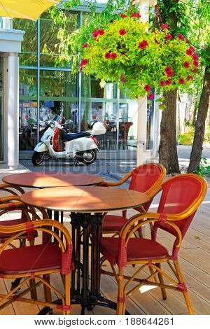 Jurmala Latvia - August 18 2013: Street cafe with tables and chairs and scooter parked at the building Jurmala Latvia recreational resort