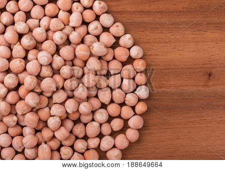 Heap of chick peas chickpeas on a dark board with an empty space for your text. Top view close-up.