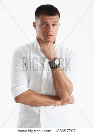 A Man Holds His Hand To His Chin Against A White Background. Pretending To Look At The Camera