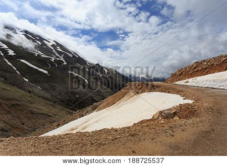 Mountain Landscape With Snow Peaks With Melting Snow And Clouds