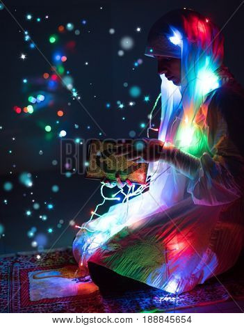 Muslim woman praying in dark room with nice lights around her