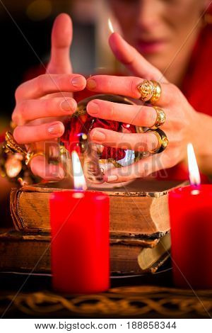 Female Fortuneteller or esoteric Oracle, sees in the future by looking into their crystal ball during a Seance to interpret them and to answer questions