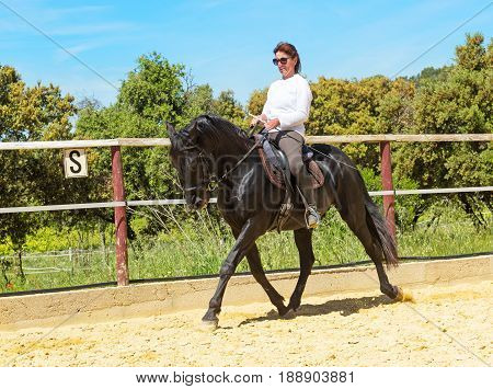 riding woman on a white stallion training in dressage