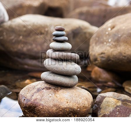 Pyramid Of Stones On A Background Sea Of Large Stones And Water