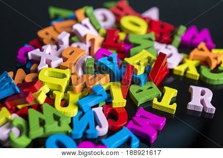 A Lot Of Colored Letters On A Black Background.