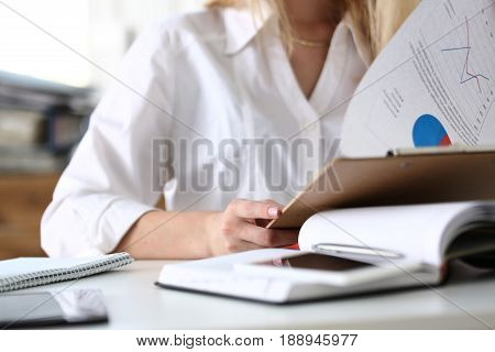Female Hands Hold Clipboard Pad With Financial Statistics
